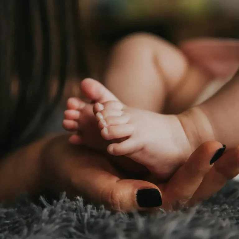 Hand cradling baby feet